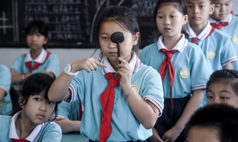 Students line up to get their eyes tested at a primary school in Huzhou City, Zhejiang province.