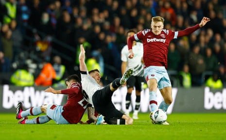 West Ham United’s Nayef Aguerd (left) hits the deck under a challenge from Derby County’s James Collins as West Ham’s Flynn Downes escapes with the ball.
