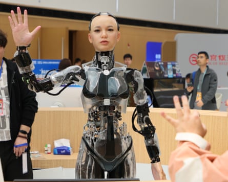 A humanoid robot shakes hands with a journalist at the Zhongguancun Forum in Beijing, March 2025.
