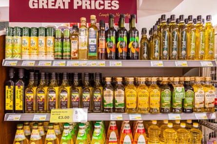 a supermarket shelf stacked with olive oils