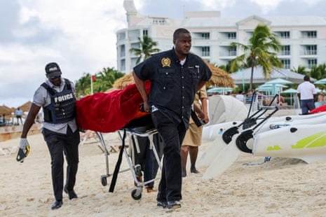 Mortuary services personnel transport the body of a victim of a fatal shark attack in the Bahamas.
