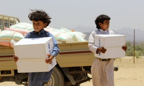 Displaced Yemeni children carry boxes of humanitarian aid donated by UNICEF outside their shelter of Sirwah, east of the capital Sanaa, on Monday.