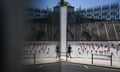 A woman walks past the Lisbon University of Social and Human Sciences walls, stenciled with red carnations, in Lisbon. 