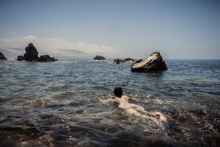 Jade Lotus, from London, swims naked on the ocean near Praia do Amado, Portugal.