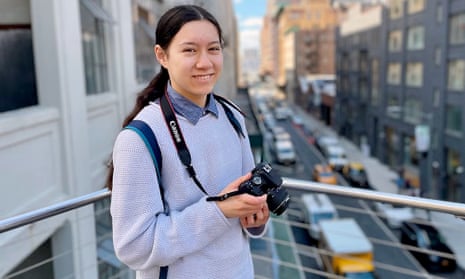 Caitlyn Scott-Lee smiling and holding a camera in a city street