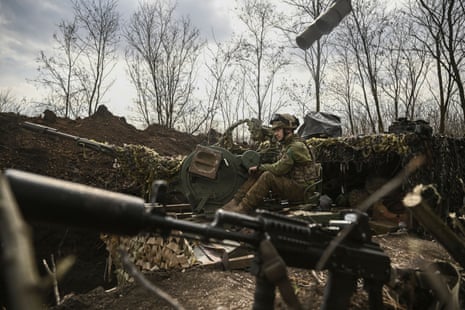 An Ukrainian serviceman sits on an anti-air gun near Bakhmut.