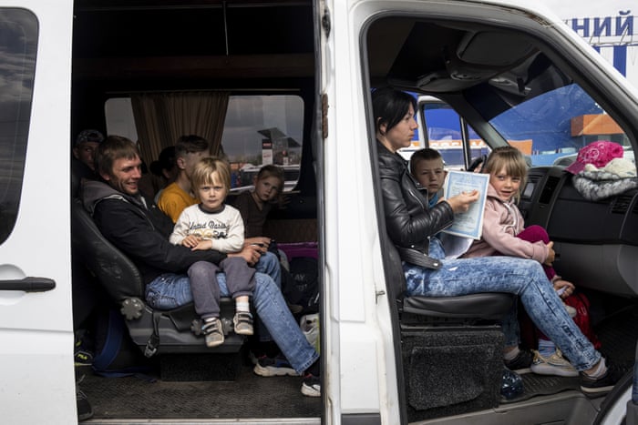 People with children wait after arriving from the Ukrainian city of Tokmak at a centre for displaced people in Zaporizhzhia, Ukraine.
