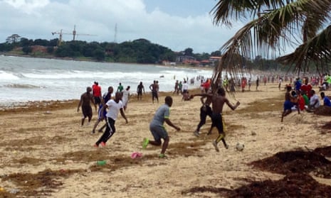 People play football on a beach in Freetown, Sierra Leone.