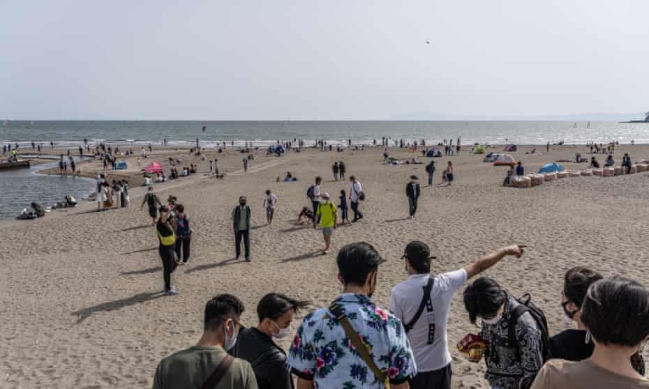 Pessoas relaxam na praia de Yuigahama em Kamakura, Japão.