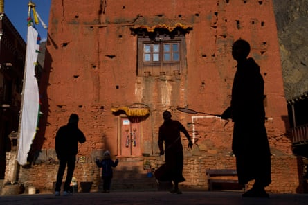 they are silhouetted against the red brick building