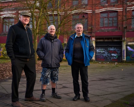 Three men outside the derelict property