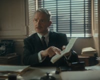 Martin Freeman sat at a desk holding a piece of paper