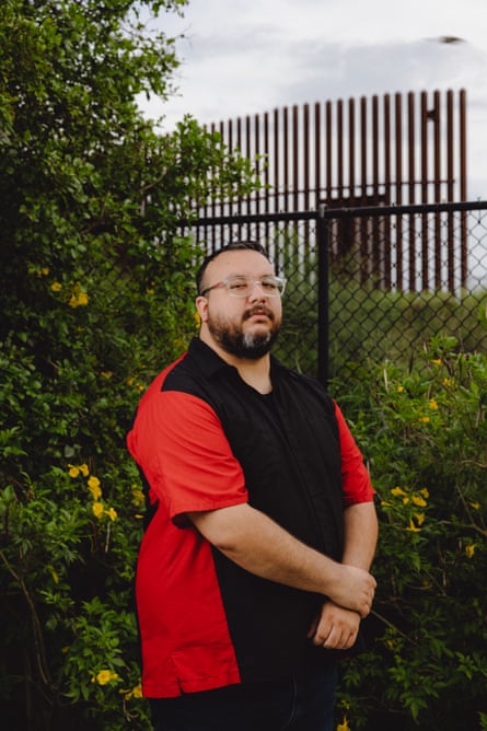 a man stands in front of fence