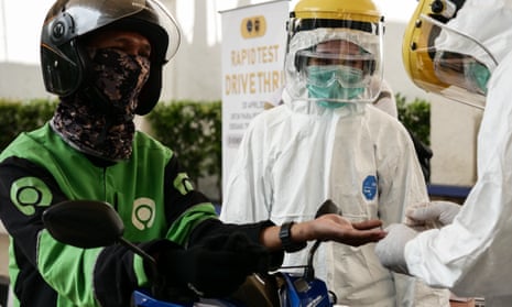 Medical staff conduct a coronavirus rapid test at a drive-through system in Jakarta, Indonesia.