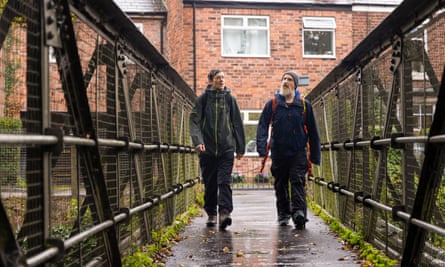 Two men, including Daniel Raven-Ellison, right, walking over a footbridge in an urban area