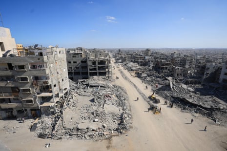 Palestinians walk past the rubble of destroyed buildings, amid a ceasefire between Israel and Hamas, in Gaza City, October 16, 2025.