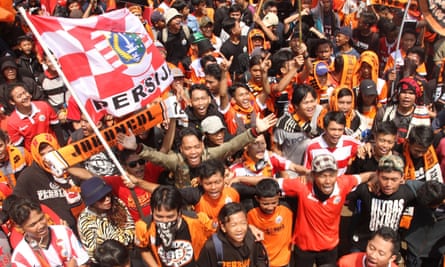 Dressed in their trademark orange uniforms, Jakmania fans protest following violent clashes with the police.
