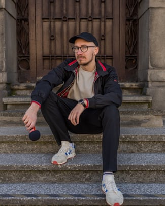 Mateusz Demski, a presenter at Radio Krakow who lost his job due to AI, sitting on stone steps holding a mic