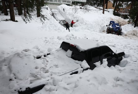 Residents attempt to shovel out their driveway after a series of winter storms in the San Bernardino Mountains in Southern California.