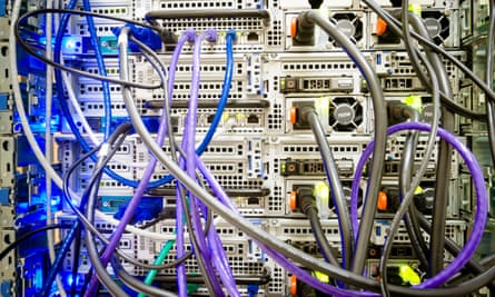 Ethernet and power cables plugged into the back of a computer server machine at a datacentre.