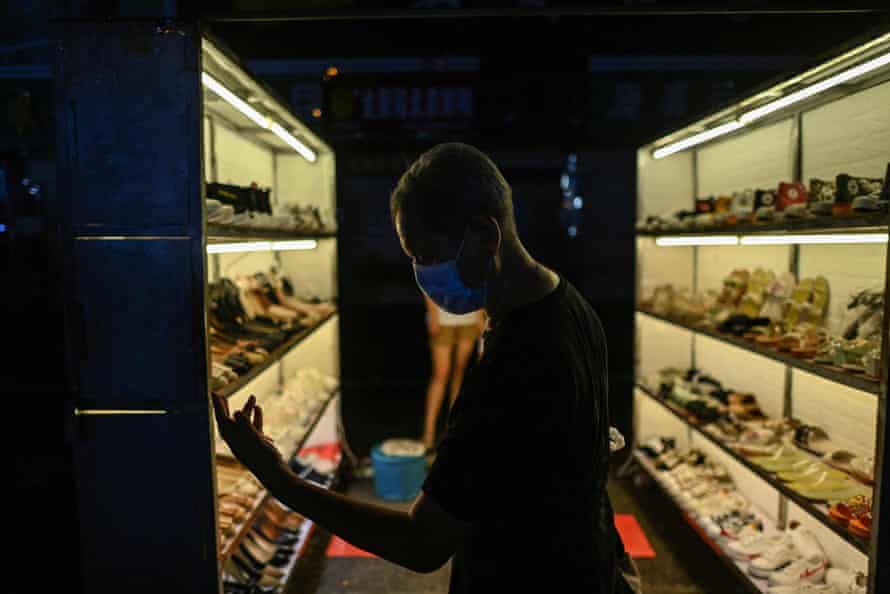 A man walking next to a stand at a night market in Wuhan in Chinas central Hubei province