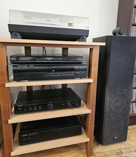 A wooden unit with a turntable on top and amps and CD players on the shelves below