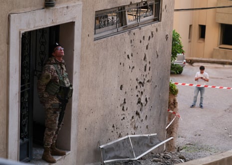 एक क्षतिग्रस्त इमारत के पास एक सैनिक