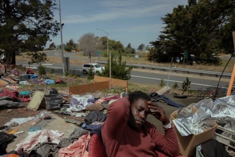 A person rest in front of a homeless encampment