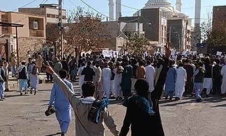 Men holding hands making V signs as they join crowd of people in street.
