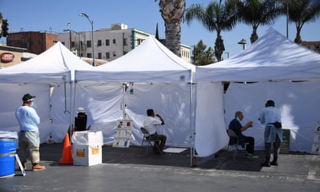 People use a mouth swab to collect their own sample at a walk-up coronavirus testing location in Los Angeles, California, on 10 August.