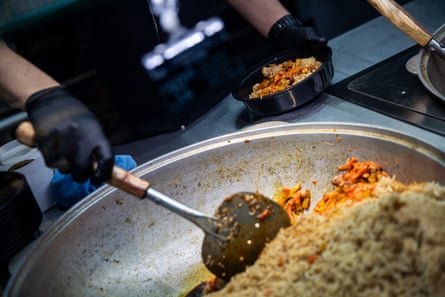 an worker scoops a atom crockery into a integrative container