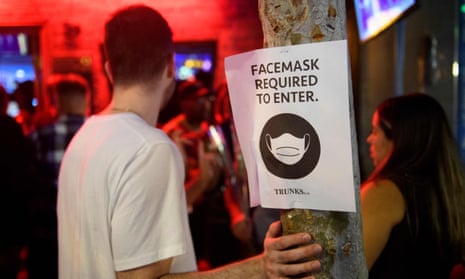 Face mask signage is seen outside a bar in West Hollywood, California. 