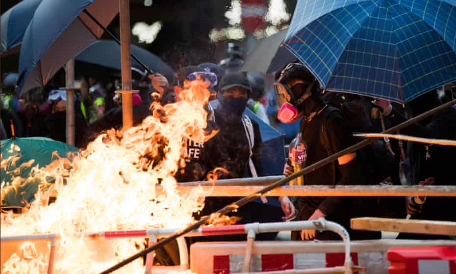 Hundreds of thousands defy Hong Kong’s protest ban, as police fire water canon with dye and pepper solution in busy shopping thoroughfare. 