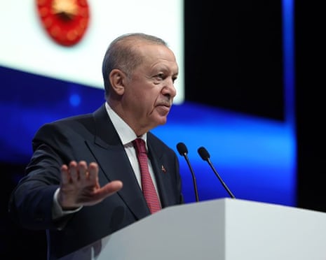 Recep Tayyip Erdoğan gesturing as he talks at a lecturn