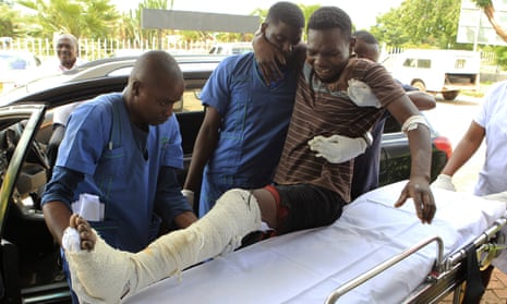 An injured man is helped at a private hospital in Harare