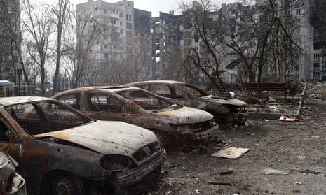 Charred cars in front of a heavily damaged apartment building in the besieged city of Mariupol.