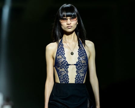 A model wearing a lacy, patterned see-through halterneck top