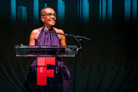 A woman speaks into a microphone at a lectern.