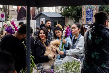People shop at a market in preparation for Nowruz celebrations on 19 March 2026 in Tehran, Iran.