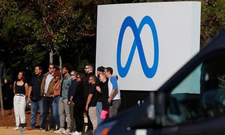 Facebook 员工聚集在位于加利福尼亚州门洛帕克的 Facebook 总部前展示 Meta 品牌重塑新标志的标志前。 