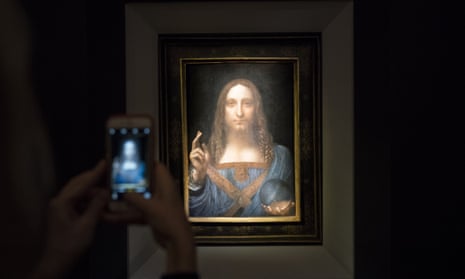 A visitor takes a photo of the painting Salvator Mundi by Leonardo da Vinci at Christie’s New York auction house.
