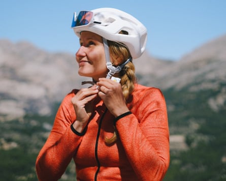 Young woman puts on a bicycle helmet