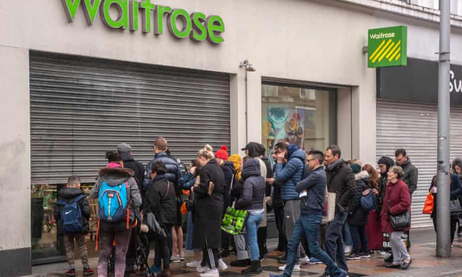 Early morning shoppers wait for a branch of Waitrose to open in south London.