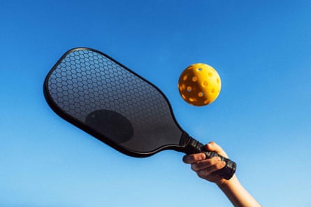 a person hitting a pickleball with a paddle