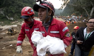 رجل إطفاء يحمل جثة طفل من الانهيار في Cambray في ضاحية سانتا كاتارينا Pinula، حوالي 10 ميلا شرق مدينة غواتيمالا يوم الجمعة. 