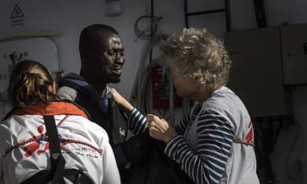 A migrant reacts as he is greeted by MSF workers aboard the Aquarius