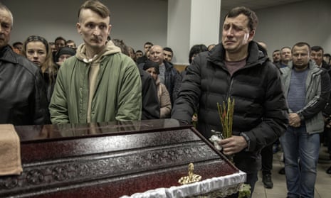 Relatives of serviceman Anatoliy Yalovskyi, who died at the age of 38, mourn in front of his coffin during his funeral in Kyiv, Ukraine on 27 March 2023. 