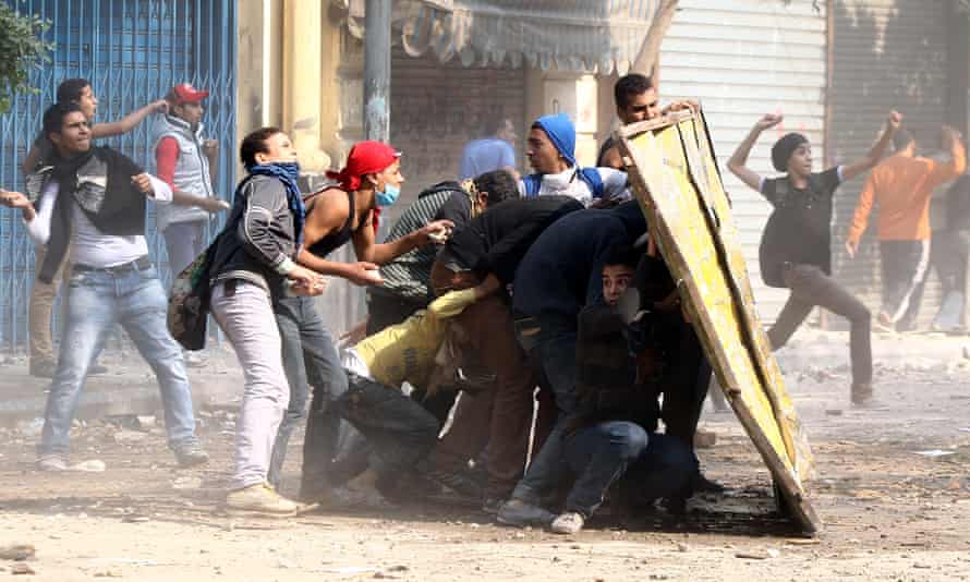 Los manifestantes se protegen de los gases lacrimógenos durante los enfrentamientos con las fuerzas policiales cerca de la plaza Tahrir, El Cairo, el 22 de noviembre de 2012.