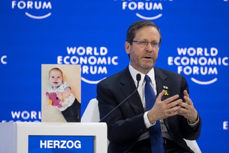 Israeli President Isaac Herzog speaks next to a photograph of baby Kfir Bibas, abducted by Hamas on 7 October.