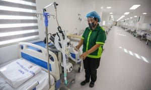 A worker cleans equipment inside a ward of a field hospital for Covid patients at a park in Manila on 24 June 2021.